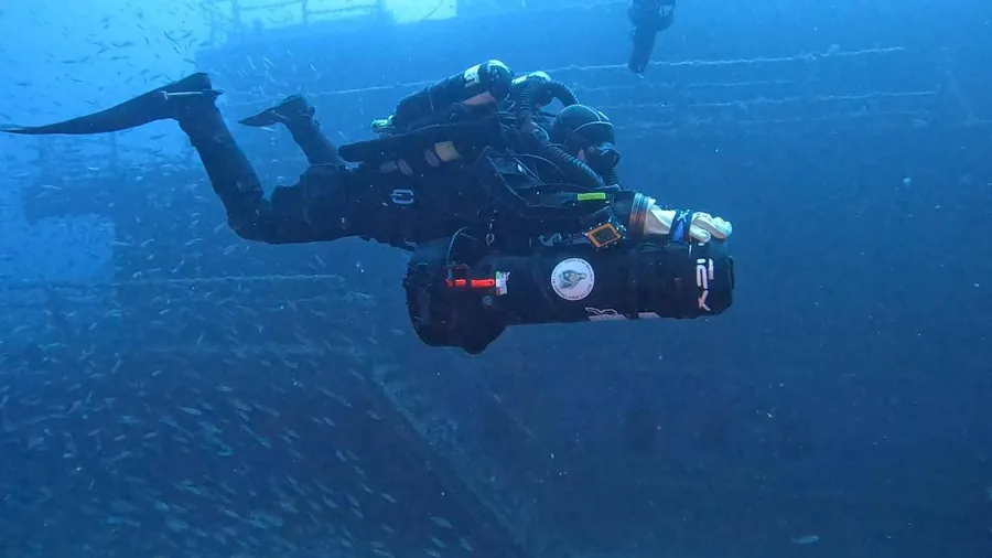 Diver with closed-circuit rebreathers next to a wreck