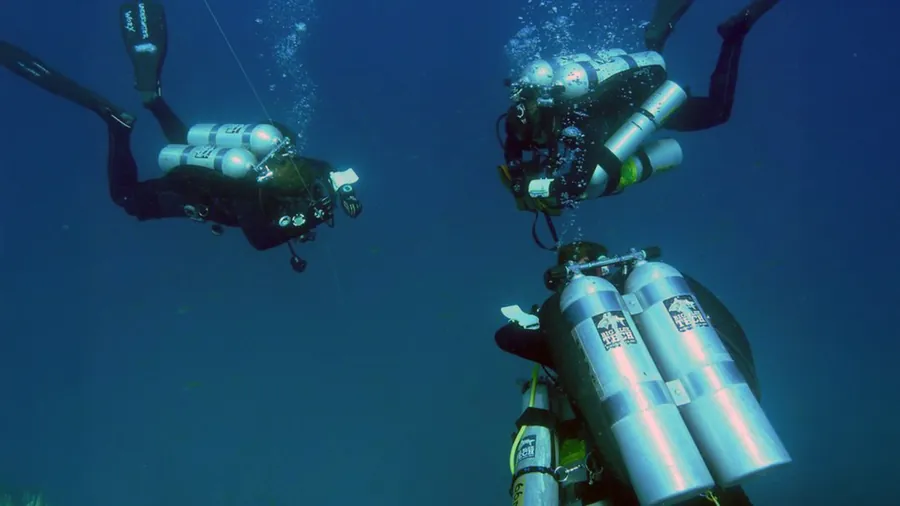 Technical diver with decompression cylinders in open water