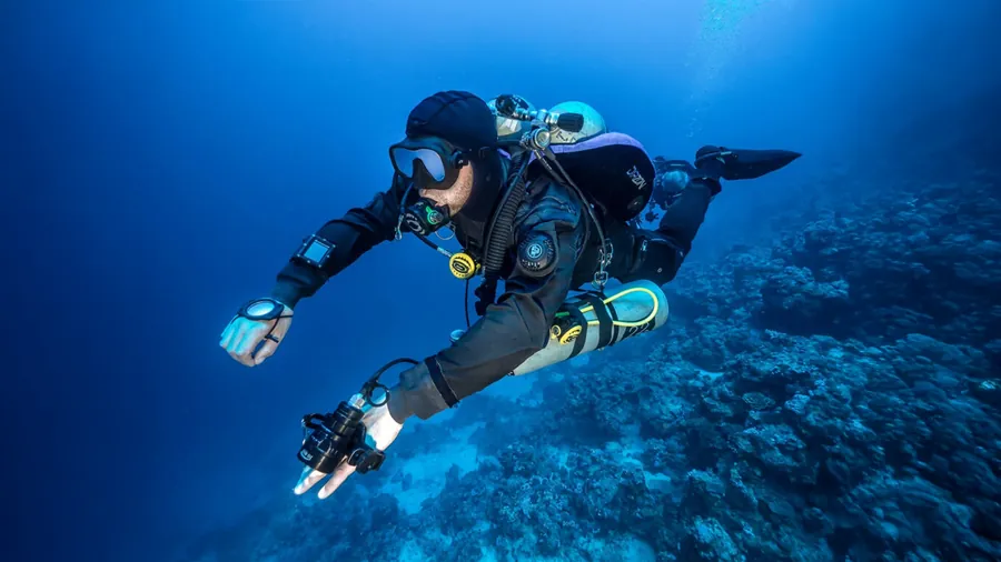 Technical diver with several cylinders in the blue