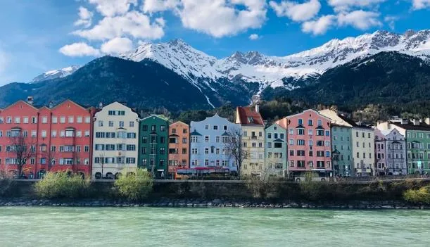 Casas de colores junto al río Inn en Innsbruck con montañas nevadas