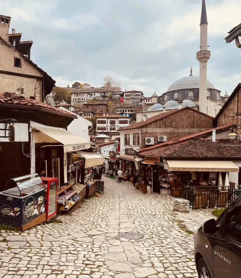 Calle empedrada con tiendas tradicionales y una mezquita al fondo